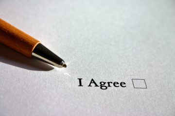 A pen rests just above an unfilled check box that says "I agree".